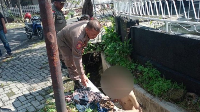 Petugas Satpol PP Surabaya mengevakuasi pria ODGJ yang berendam di selokan