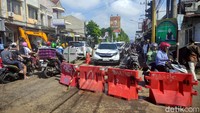 Satu unit alat berat diturunkan ke lokasi untuk mempercepat perbaikan aspal jalan yang ambles.