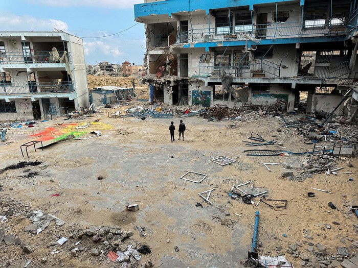 Palestinian school children Abed Al-Qara and Muhammad Al-Fajem inspect their school which was destroyed during Israels military offensive, amid the ongoing conflict between Israel and Hamas, in Khan Younis in the southern Gaza Strip, April 14, 2024. REUTERS/Doaa Rouqa