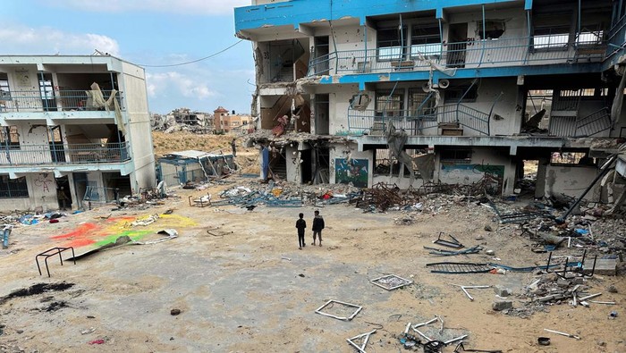 Palestinian school children Abed Al-Qara and Muhammad Al-Fajem inspect their school which was destroyed during Israel's military offensive, amid the ongoing conflict between Israel and Hamas, in Khan Younis in the southern Gaza Strip, April 14, 2024. REUTERS/Doaa Rouqa