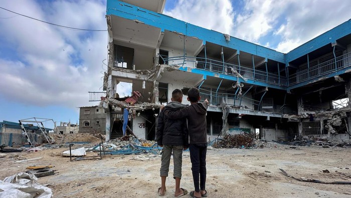 Potret Anak-anak Gaza Memandang Sekolah Mereka yang Hancur Palestinian school children Abed Al-Qara and Muhammad Al-Fajem inspect their school which was destroyed during Israel's military offensive, amid the ongoing conflict between Israel and Hamas, in Khan Younis in the southern Gaza Strip, April 14, 2024. REUTERS/Doaa Rouqa