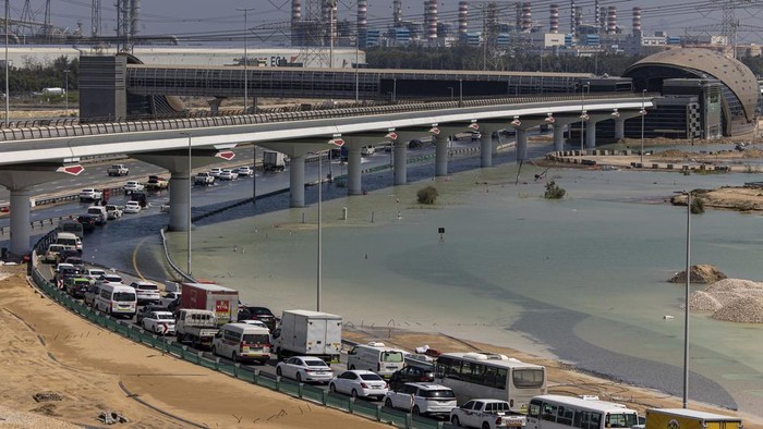 Potret Kemacetan Panjang di Dubai Gegara Jalan Terendam Banjir Vehicles drive through standing floodwater caused by heavy rain on Sheikh Zayed Road highway in Dubai, United Arab Emirates, Thursday, April 18, 2024. The United Arab Emirates attempted to dry out Thursday from the heaviest rain the desert nation has ever recorded, a deluge that flooded out Dubai International Airport and disrupted flights through the world's busiest airfield for international travel. (AP Photo/Christopher Pike)