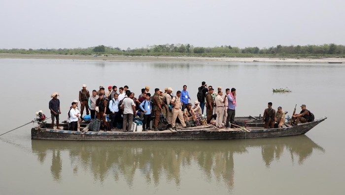 Polling and police officers travel in a boat with election materials to reach to a remote polling station ahead of the first phase of India's general election in the Majuli district, in the northeastern state of Assam, India, April 18, 2024. REUTERS/Stringer
