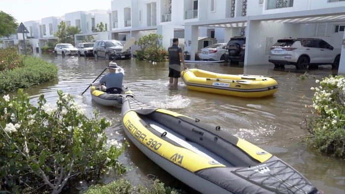 A man walks through floodwater in the Mudon neighborhood in Dubai, United Arab Emirates, Thursday, April 18, 2024. The United Arab Emirates attempted to dry out Thursday from the heaviest rain the desert nation has ever recorded — a deluge that flooded out Dubai International Airport and disrupted flights through the world's busiest airfield for international travel. (AP Photo/Jon Gambrell)
