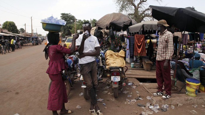 Amadou Coulibaly, a 25-years-old, motorcycle taxi driver, drinks a sachet water to cool off under a blazing sun.in Bamako, Mali, Thursday, April, 18, 2024. Street vendors in Mali's capital of Bamako peddle water sachets, ubiquitous for this part of West Africa during the hottest months of the year. On Thursday, temperatures in Bamako reached 44 degrees Celsius (111 Fahrenheit) and weather forecasts say it's not letting up anytime soon. (AP Photo/Baba Ahmed)