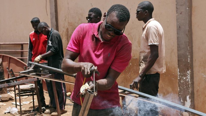 Warga Mali Kewalahan Hidup di Tengah Cuaca Panas Ekstrem Amadou Coulibaly, a 25-years-old, motorcycle taxi driver, drinks a sachet water to cool off under a blazing sun.in Bamako, Mali, Thursday, April, 18, 2024. Street vendors in Mali's capital of Bamako peddle water sachets, ubiquitous for this part of West Africa during the hottest months of the year. On Thursday, temperatures in Bamako reached 44 degrees Celsius (111 Fahrenheit) and weather forecasts say it's not letting up anytime soon. (AP Photo/Baba Ahmed)