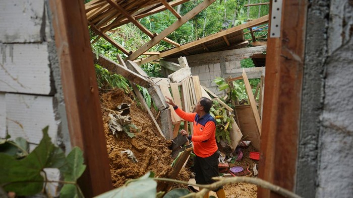 12 Rumah di Trenggalek Rusak Akibat Tanah Longsor Petugas meninjau rumah terdampak tanah longsor di Desa Sumurup, Trenggalek, Jawa Timur, Sabtu (20/4/2024). BPBD Trenggalek melaporkan sedikitnya 12 rumah warga yang tersebar di lima kecamatan daerah itu dilaporkan rusak berat dan sebagian tidak layak huni akibat diterjang tanah longsor sehingga 35 jiwa harus diungsikan sementara ke tempat aman. FOTO/Destyan Sujarwoko/YU