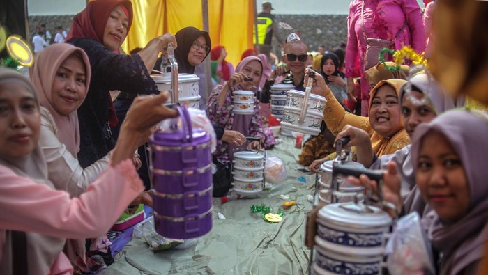 Warga berfoto dengan ondel-ondel saat mengikuti kegiatan budaya Lebaran Kukusan di Kawasan Kukusan, Depok, Jawa Barat, Sabtu (20/4/2024). Silahturahmi bertema Lebaran Kukusan dengan kegiatan makan bersama itu merupakan napak tilas suasana Lebaran suku Betawi tempo dulu yang bertujuan untuk melestarikan budaya daerah . ANTARA FOTO/Yulius Satria Wijaya/Spt.