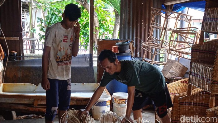 M Asad sedang menyusun bahan baku rotan (Andika Syahputra/detikcom)