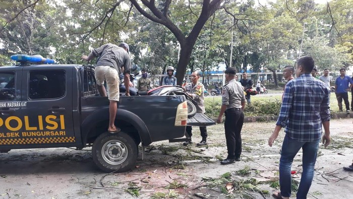 Polisi saat melakukan evakuasi motor korban tertimpa pohon di Purwakarta.
