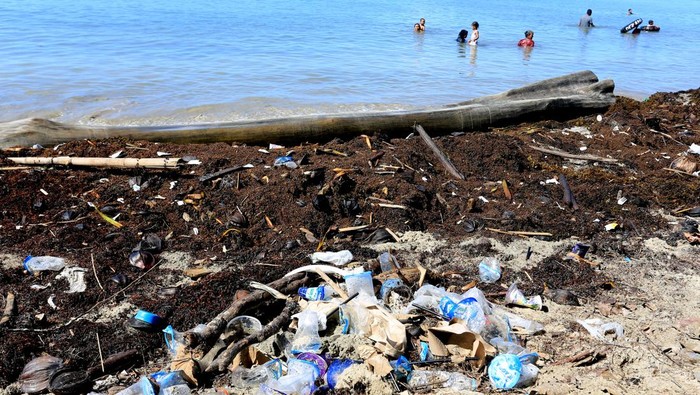 Sampah pantai pascalibur lebaran di Aceh Barat Pengunjung berenang dengan latar depan sampah yang berserakan di kawasan objek wisata pantai Desa Lhok Bubon, Aceh Barat, Aceh, Minggu (21/4/2024). Sejumlah objek wisata pantai di Kabupaten Aceh Barat dipenuhi sampah plastik dan makanan kemasan pascalibur lebaran Idul Fitri 1445 Hijriah akibat kurangnya kesadaran pengujung dalam menjaga lingkungan sekitar. ANTARA FOTO/Syifa Yulinnas/wpa.