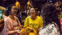 Orang-orang mengolesi lumpur hitam ke wajah satu sama lain di Qiandongnan, Guizhou, China , Jumat (19/4/2024).