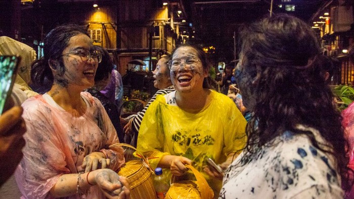 Warga di Qiandongnan, China mengoleskan lumpur hitam ke wajah satu sama lain. Hal itu sebagai bentuk mendoakan sebuah keberuntungan.