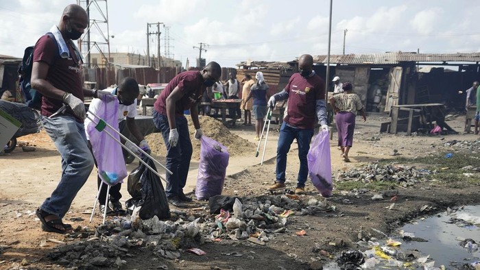 Aksi Relawan Bersihkan Sampah di Pasar Lagos yang Terkenal Kotor Volunteers from Sustyvibes, a Non-profit organization, pick up trash on a street near a market ahead of World Earth Day, in Lagos, Nigeria, Saturday, April 20, 2024. (AP Photo/Sunday Alamba)