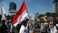 Massa aksi juga mengibarkan bendera merah putih dalam aksi yang berlangsung di kawasan Patung Kuda.