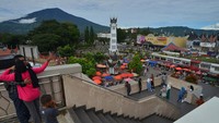 Pengunjung menikmati panorama Jam Gadang dan Gunung Singgalang dari Pasar Ateh Bukittinggi, Sumatera Barat, Minggu (21/4/2024).