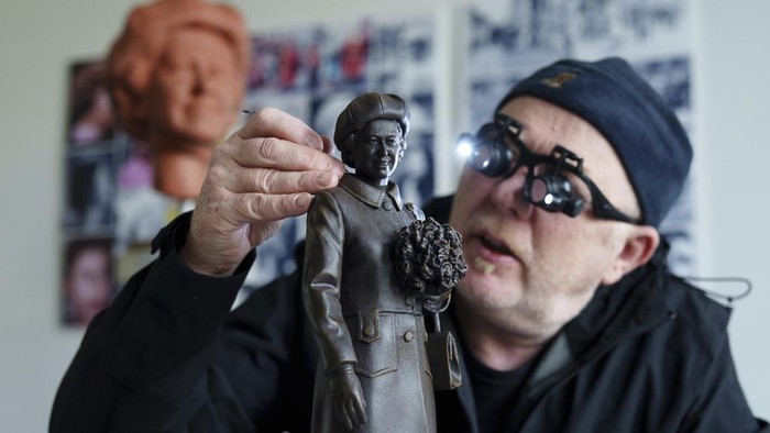 Staffordshire sculptor Andy Edwards poses for a picture while fine-tuning a scale model of his statue of Queen Elizabeth II commissioned by Newcastle-under-Lyme Borough Council to mark the borough's 850th anniversary, Newcastle-Under-Lyme, England, Thursday, April 18, 2024. Edwards whose previous works include the landmark Beatles statue at Liverpool's Pier Head, is basing the sculpture on photographs of the late Queen's visit to Newcastle-under-Lyme as part of the Borough's 800th anniversary celebrations in 1973. (AP Photo/Jon Super)