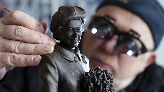Staffordshire sculptor Andy Edwards poses for a picture while fine-tuning a scale model of his statue of Queen Elizabeth II commissioned by Newcastle-under-Lyme Borough Council to mark the borough's 850th anniversary, Newcastle-Under-Lyme, England, Thursday, April 18, 2024. Edwards whose previous works include the landmark Beatles statue at Liverpool's Pier Head, is basing the sculpture on photographs of the late Queen's visit to Newcastle-under-Lyme as part of the Borough's 800th anniversary celebrations in 1973. (AP Photo/Jon Super)