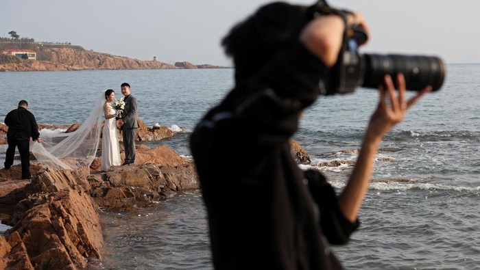 Couples take part in their pre-wedding photoshoots by the sea in Qingdao, Shandong province, China April 21, 2024. REUTERS/Florence Lo     TPX IMAGES OF THE DAY