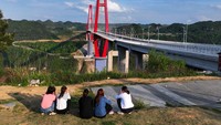 Tampak warga duduk santai di dekat jembatan sungai Longli.