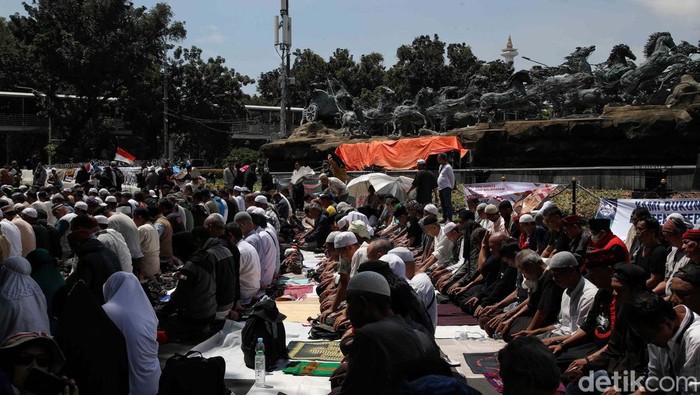 Para pendemo yang beraksi di Patung Kuda, Jakarta, menggelar salat dzuhur berjemaah. Salat dilakukan di sela-sela aksi menunggu putusan sidang sengketa Pilpres 2024.