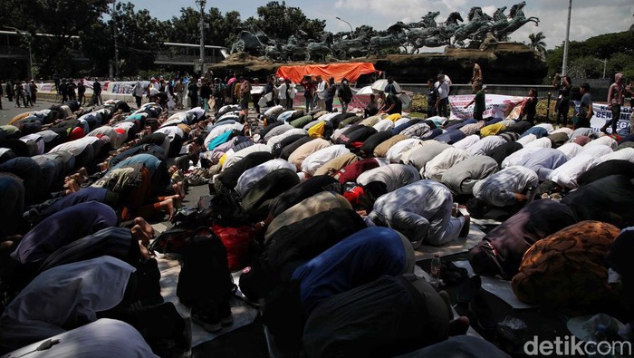 Para pendemo yang beraksi di Patung Kuda, Jakarta, menggelar salat dzuhur berjemaah. Salat dilakukan di sela-sela aksi menunggu putusan sidang sengketa Pilpres 2024.