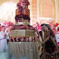 Sesuai dengan nuansa di resepsi pernikahan yang didominasi warna merah dan gold, kue pengantin yang terdiri dari 7 tingkat itu pun dibuat senada. Pada bagian depannya terdapat nama kedua pengantin. Foto: Instagram/@da4_putri03