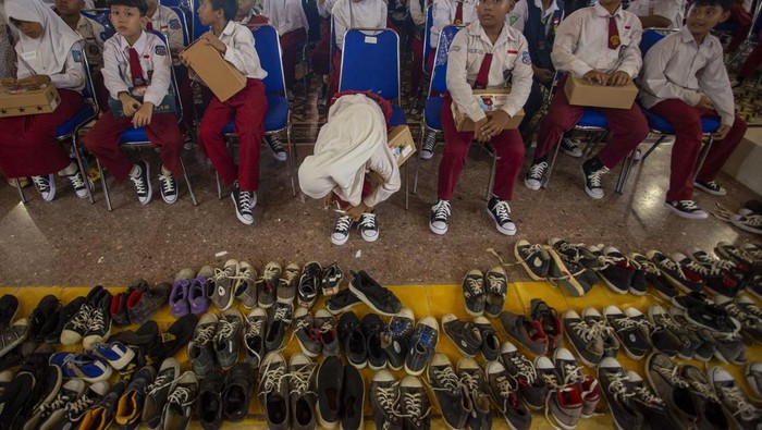 Siswa memakai sepatu baru yang diterima di Pendopo Indramayu, Jawa Barat, Senin (22/4/2024). Pemkab Indramayu menyalurkan 1000 pasang sepatu untuk anak-anak tingkat SD dan SMP yang membutuhkan. ANTARA FOTO/Dedhez Anggara/wpa.
