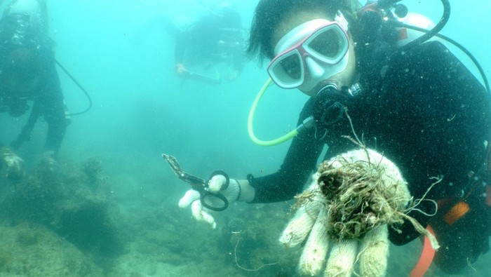 Aksi Penyelam Thailand Bersihkan Sampah Plastik di Perairan Phuket A scuba diver shows to the camera abandoned fishing nets removed from a coral reef in Phuket, Thailand, April 4, 2024. REUTERS/Napat Wesshasartar