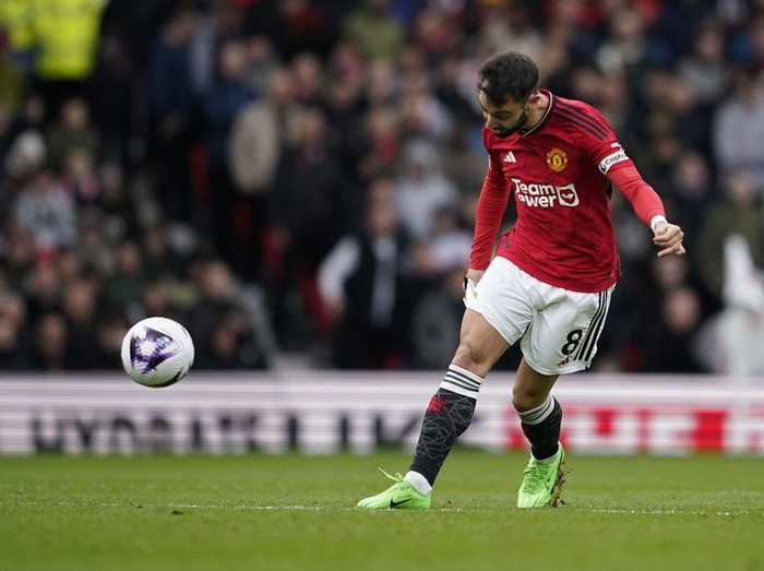 Manchester United's Bruno Fernandes scores his side's first goal during the English Premier League soccer match between Manchester United and Liverpool at the Old Trafford stadium in Manchester, England, Sunday, April 7, 2024. (AP Photo/Dave Thompson)