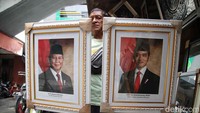 Seorang pedagang memperlihatkan foto Presiden dan Wakil Presiden terpilih Prabowo Subianto dan Gibran Rakabuming Raka di Pasar Baru, Jakarta Pusat, Selasa (23/4/2024).  