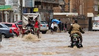 Sejumlah warga mencoba menerobos banjir saat air merendam sejumlah mobil yang tengah parkir.