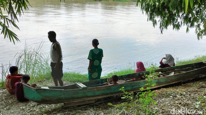 Keluarga penambang pasir yang hilang saat perahunya tenggelam berkumpul di tepi sungai menunggu proses pencarian dan evakuasi.