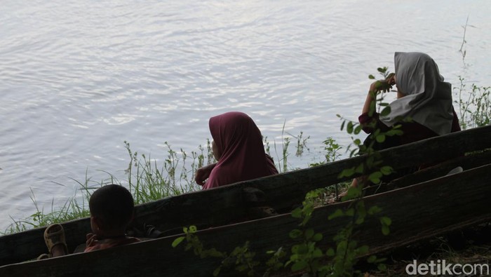 Keluarga penambang pasir yang hilang saat perahunya tenggelam berkumpul di tepi sungai menunggu proses pencarian dan evakuasi.