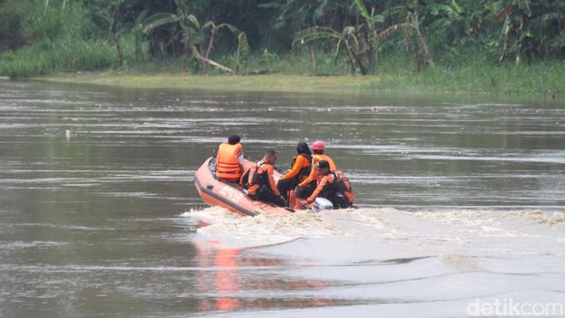 Keluarga penambang pasir yang hilang saat perahunya tenggelam berkumpul di tepi sungai menunggu proses pencarian dan evakuasi.