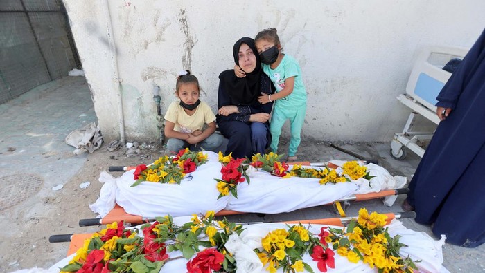 Korban Tewas Serangan Israel ke Gaza Tembus 34.000 Orang A man mourns next to the bodies of Palestinians killed in Israeli strikes, amid the ongoing conflict between Israel and the Palestinian Islamist group Hamas, in Rafah, in the southern Gaza Strip, April 21, 2024. REUTERS/Mohammed Salem