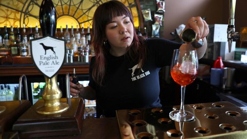 Customers sit outside The Black Dog pub, believed by its owners to have been referenced in lyrics in the song The Black Dog by Taylor Swift, in London, Britain, April 22, 2024. REUTERS/Toby Melville