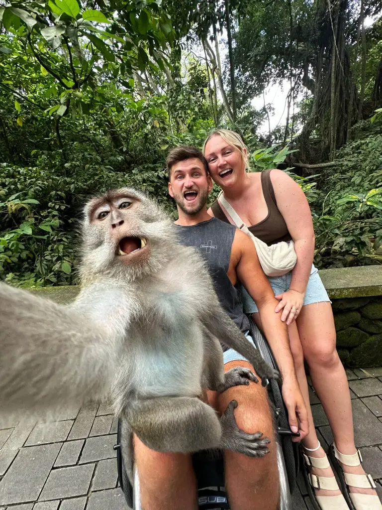 Momen langka, monyet ekor panjang selfie dengan pasangan bule di Bali. Lihat senyumnya, merekah banget!