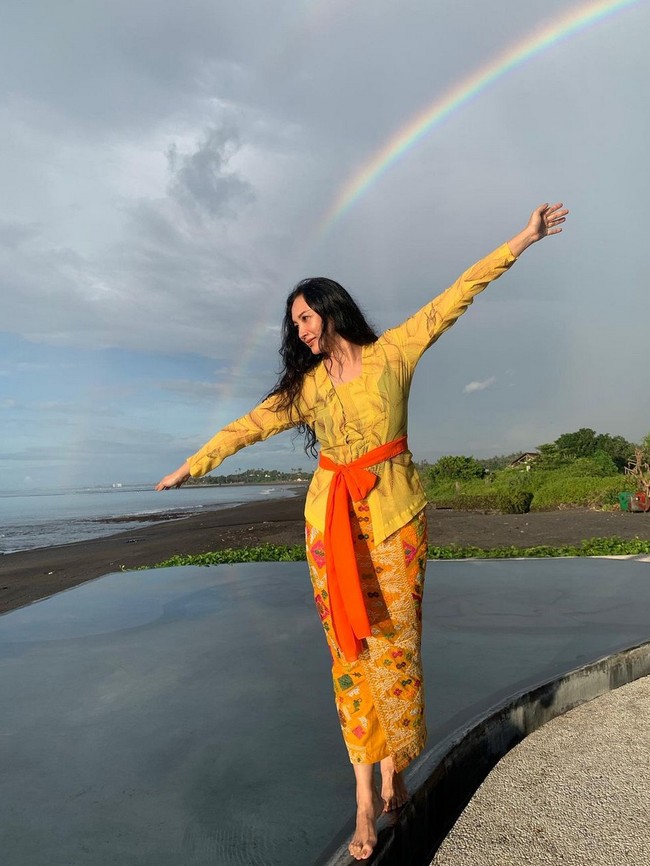 Kebaya kuning cerah dengan aksen kain di pinggang, dipadu songket Bali membuat penampilan Tata Cahyani tak hanya anggun tapi juga segar. Foto: Instagram/@tatacahyani