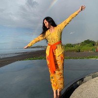 Kebaya kuning cerah dengan aksen kain di pinggang, dipadu songket Bali membuat penampilan Tata Cahyani tak hanya anggun tapi juga segar. Foto: Instagram/@tatacahyani
