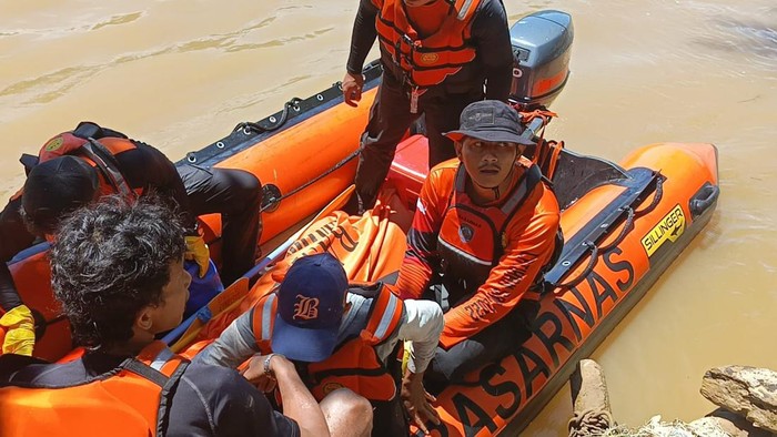 Tim gabungan mengevakuasi jasad warga yang hanyut di sungai di Pesisir Selatan. (Istimewa)