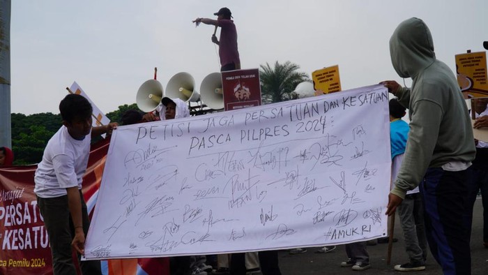 Aksi Bagikan Mawar Ajak Masyarakat Bersatu Usai Pilpres 2024 Kelompok massa mengatasnamakan Aliansi Muda Untuk Demokrasi Republik Indonesia (AMUK RI) menggelar aksi damai dengan membagikan bunga mawar di area Patung Kuda, Gambir Jakarta Pusat, Rabu (24/4/2024).