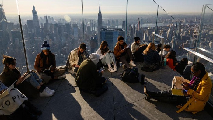 Dalam Hari Buku dan Hak Cipta Sedunia, sejumlah orang di New York membaca buku dengan pemandangan kota serta matahari pagi. Nih Potretnya.