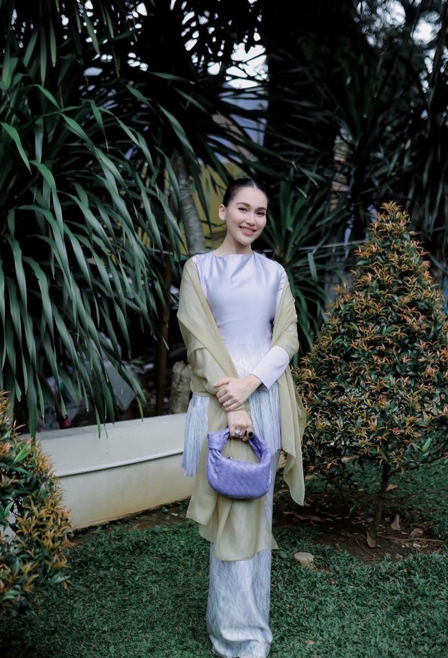 Mengenakan baju kurung berwarna ungu dipadukan dengan selendang warna coklat, penampilan Ayu terlihat memukau. Rambutnya pun tampak simpel dan rapih dengan hanya dicepol ke belakang. Foto: Instagram