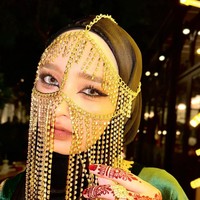 Totalitas menjelma menjadi wanita Arab, Inara tampak mengenakan cadar rantai berwarna gold dan Henna di tangannya. Riasan wajahnya, terutama bagian matanya dibuat dramatis menggunakan eyeliner pada bagian atas dan bawah matanya. Foto: Instagram/@mommy_starla