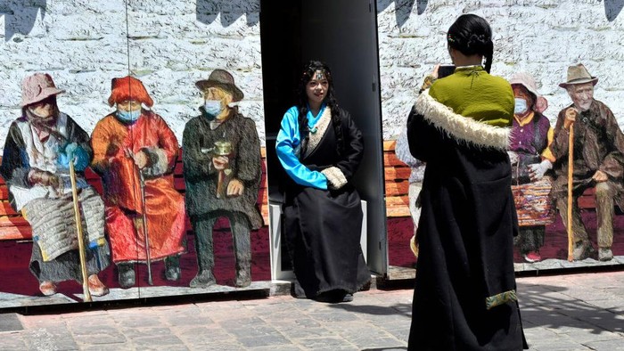 Turis mengunjungi alun-alun Kuil Jokhang di Lhasa, China. Sebagian dari mereka mengenakan kostum Tibet. Nih foto-fotonya.