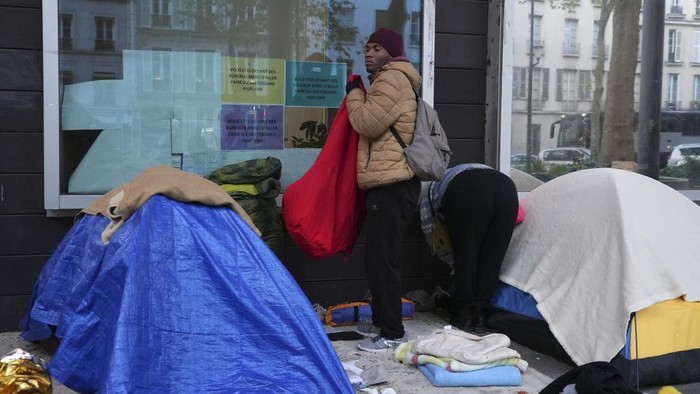 Prancis Gelar Operasi Migran Jelang Olimpiade A police officers checks a migrant's tent in a makeshift camp, early Tuesday, April 23, 2024 in Paris. French police officers have evicted migrants from a makeshift camp in Paris a few steps away from the Seine River, as similar operations have been carried out by authorities ahead of the Olympics. (AP Photo/Nicolas Garriga)