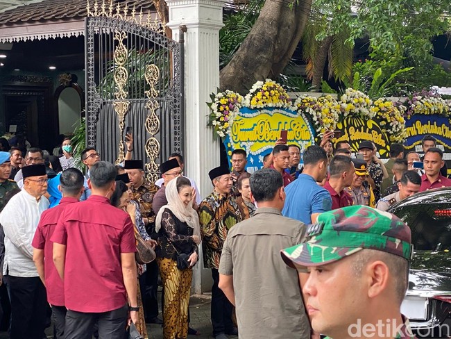 Putri Kuswisnu Wardani yang mengenakan kebaya dan kain batik serta kerudung mengantar Presiden Jokowi menuju mobilnya usai melayat ibunya, Mooryati Soedibyo. Foto: Daniel Ngantung/Wolipop