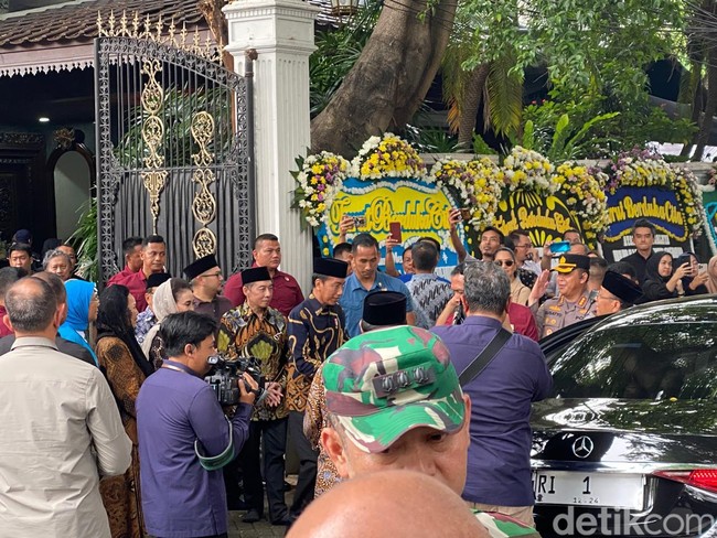 Presiden Jokowi datang dengan pengawalan ketat paspampres. Mengenakan baju batik warna royal blue, Jokowi tampak langsung memasuki rumah duka dan menyalami beberapa pelayat. Foto: Daniel Ngantung/Wolipop