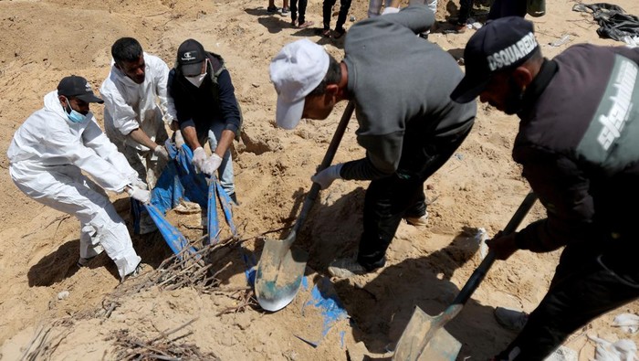 Ratusan Jenazah Ditemukan di Halaman RS Nasser Khan Younis People work to move into a cemetery bodies of Palestinians killed during Israel's military offensive and buried at Nasser hospital, amid the ongoing conflict between Israel and the Palestinian Islamist group Hamas, in Khan Younis in the southern Gaza Strip, April 21, 2024. REUTERS/Ramadan Abed TPX IMAGES OF THE DAY